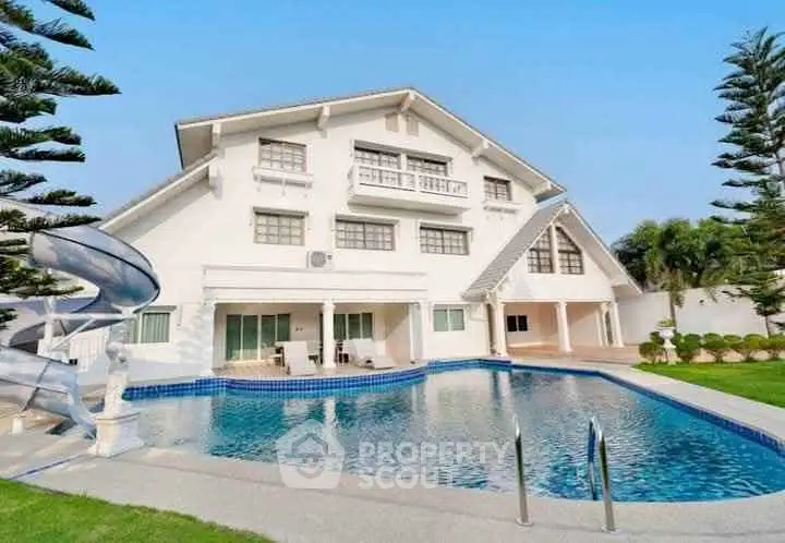 Luxurious villa with private pool and slide, surrounded by lush greenery, perfect for family retreats.