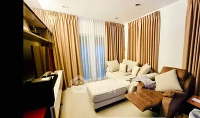 Cozy living room with plush seating and elegant curtains, perfect for relaxation.