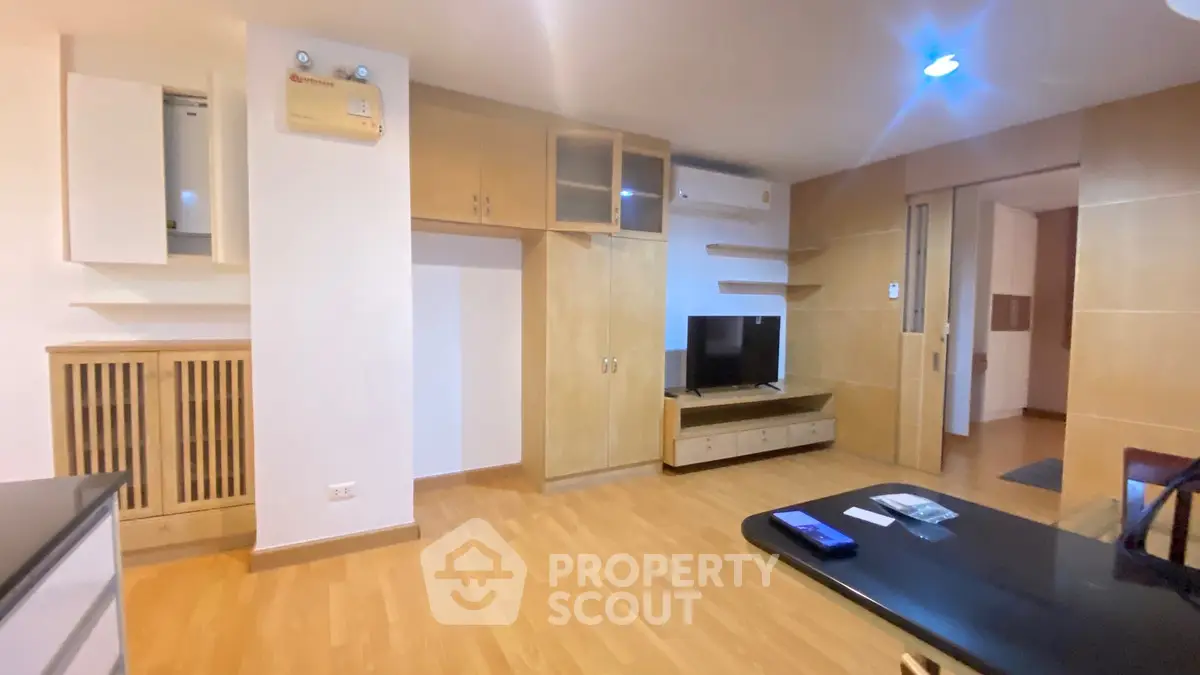 Spacious living room with modern wooden cabinetry and sleek flooring