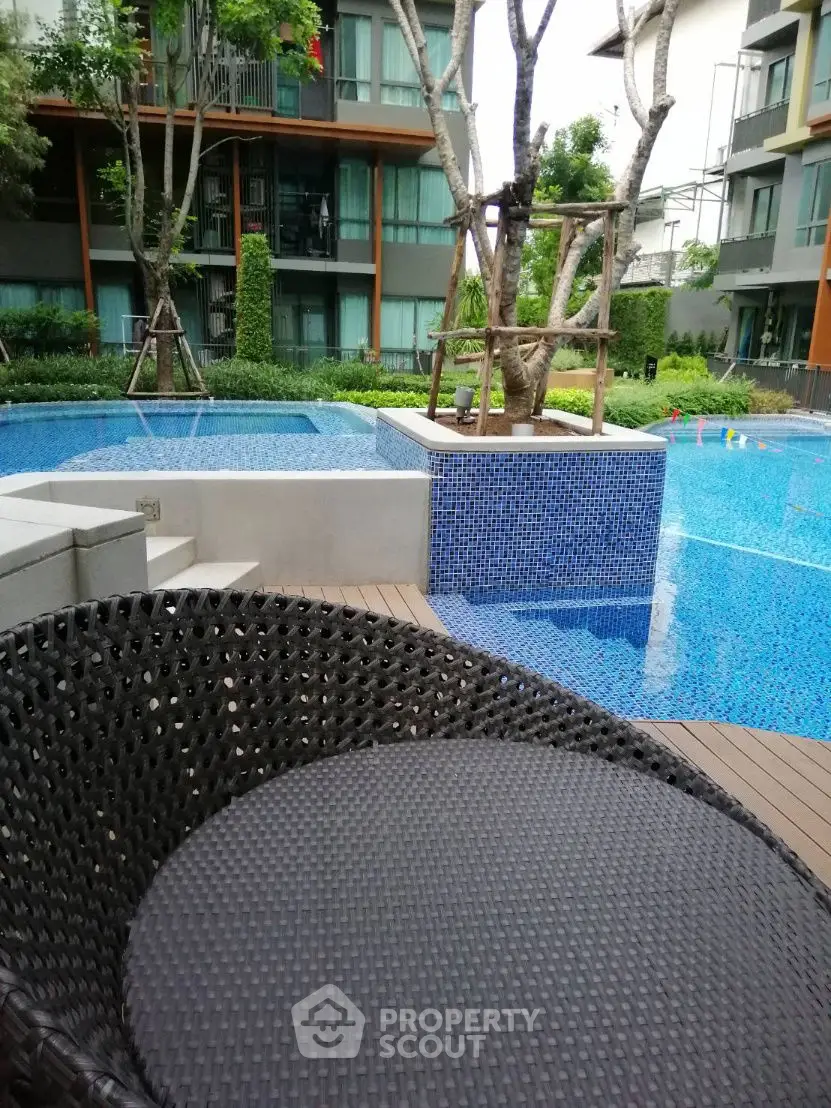 Luxurious residential pool area with modern design and lush greenery.