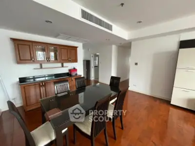 Spacious dining area with elegant wooden flooring and modern furniture in a stylish apartment.