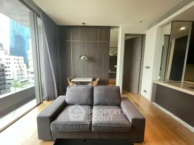 Modern living room with city view, featuring sleek furniture and floor-to-ceiling windows.
