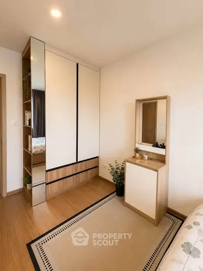 Modern bedroom with sleek wardrobe and stylish vanity in a cozy apartment.
