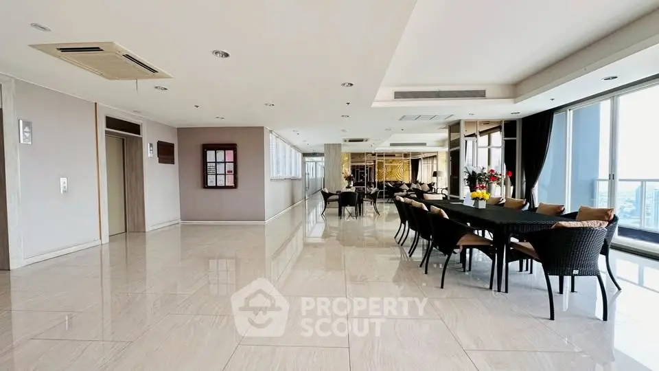 Spacious modern common area with elegant dining setup and city view.