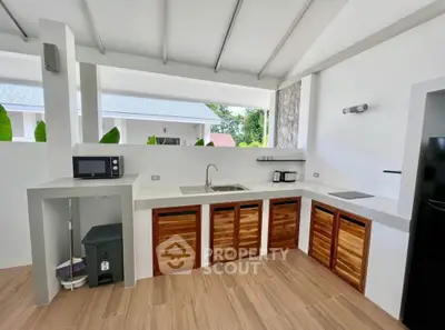 Modern open-layout kitchen with sleek appliances and wooden cabinetry, perfect for stylish cooking and entertaining.