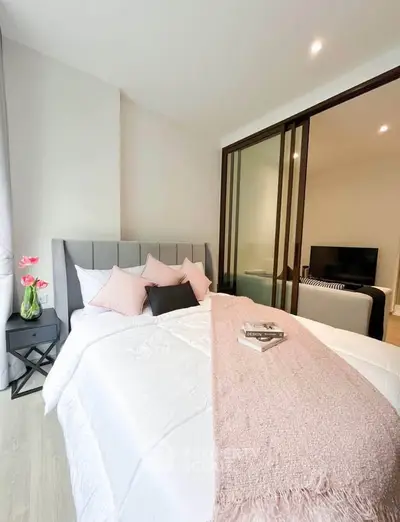 Elegant bedroom with plush bedding and sliding glass doors leading to a cozy living area.