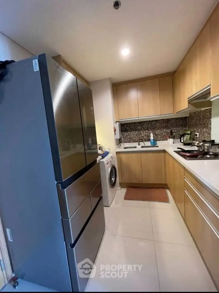 Modern kitchen with sleek appliances and stylish cabinetry in a cozy apartment setting.
