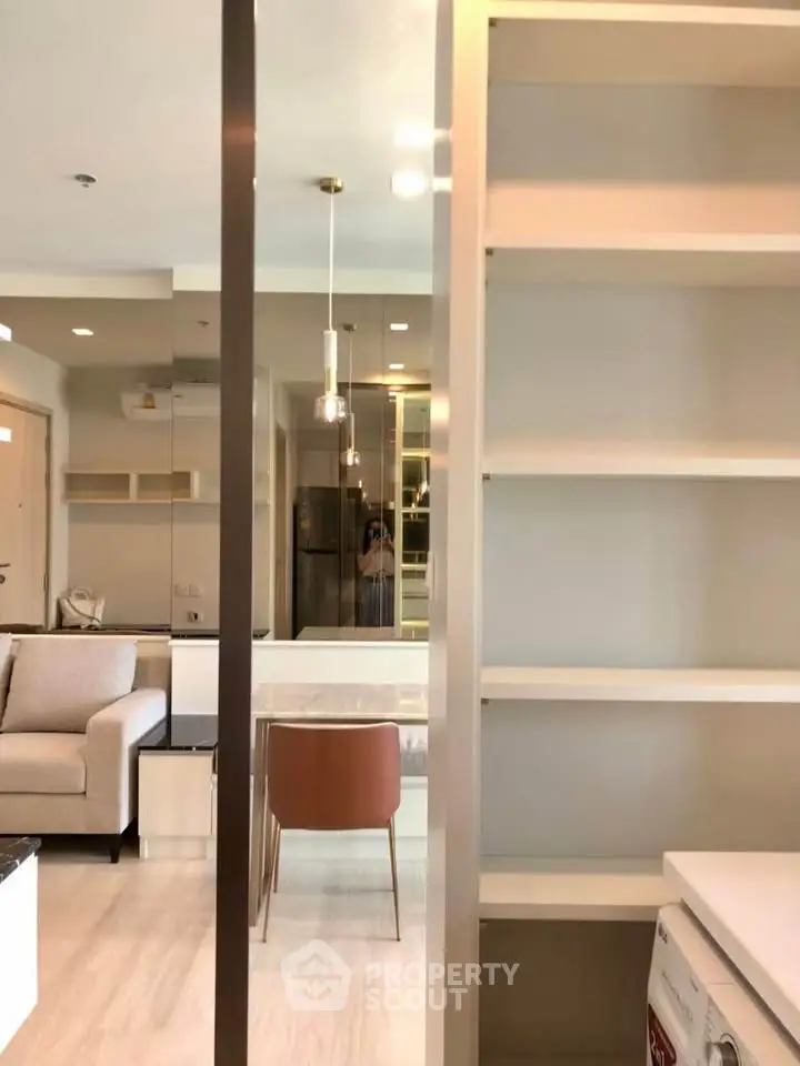 Modern living room with open layout, featuring sleek furniture and built-in shelving for a stylish urban lifestyle.