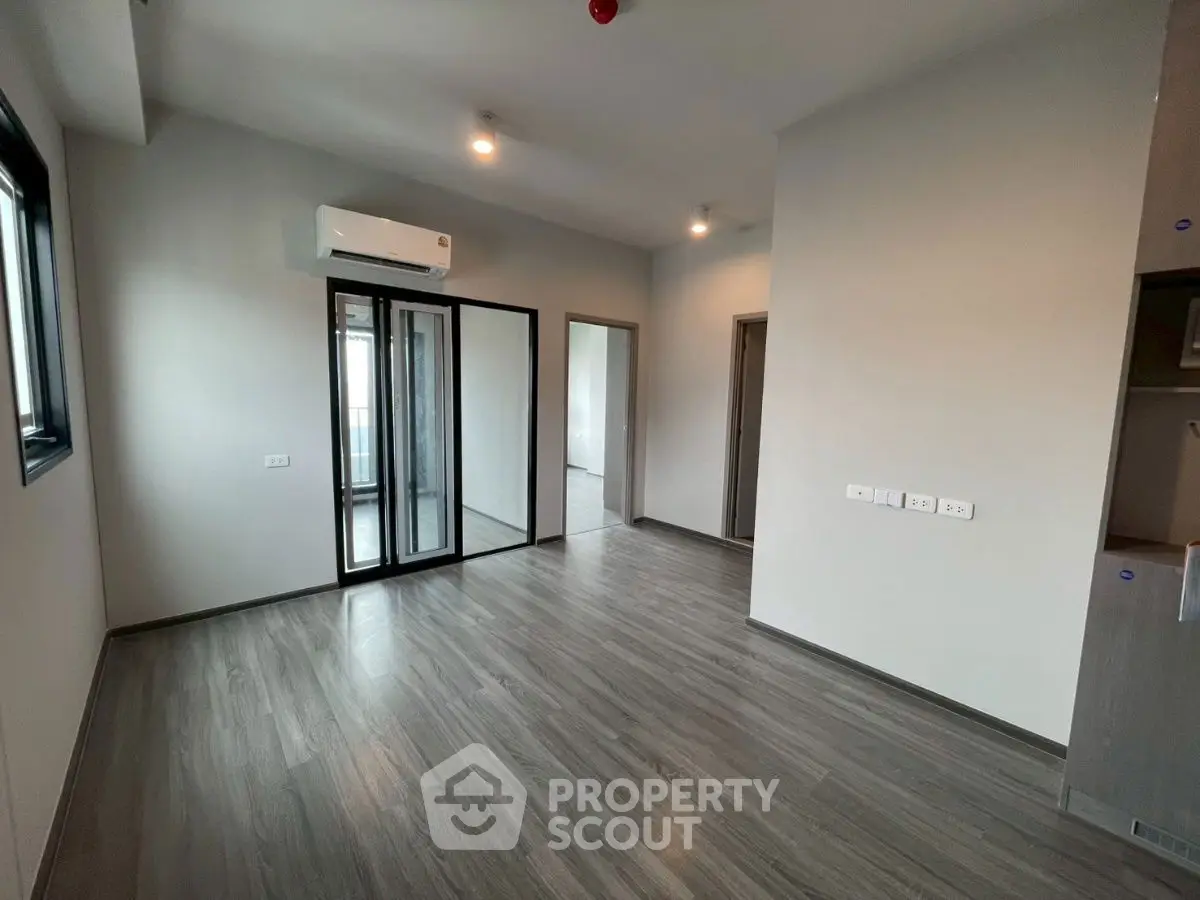 Modern apartment with sleek flooring and large windows, featuring a spacious layout and air conditioning.