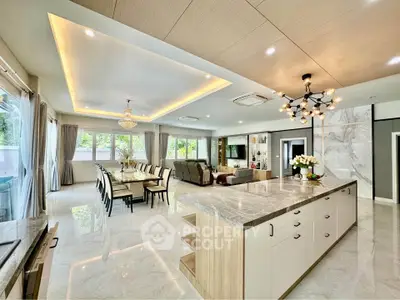 Luxurious open-plan living room and kitchen with elegant lighting and marble finishes.