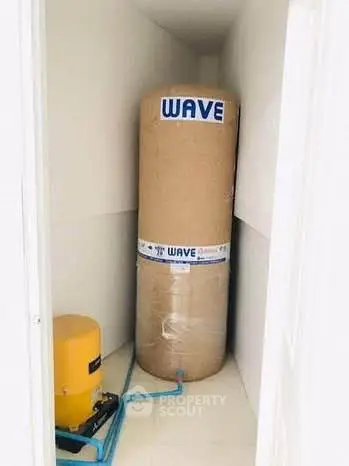 Compact storage room with water tank and pump system in modern property.