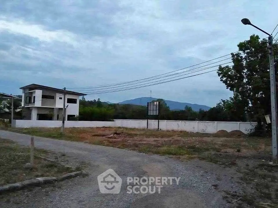 Spacious plot with mountain views and modern house, ideal for development.
