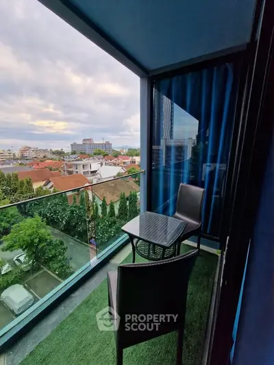 Charming balcony with city view and cozy seating area, perfect for relaxation.
