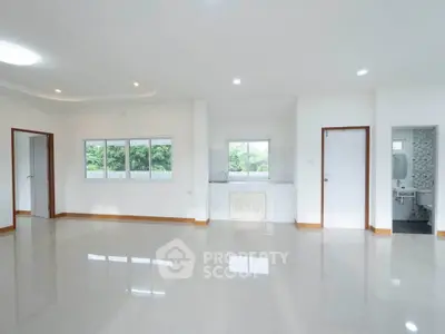 Spacious open-plan living area with large windows and natural light