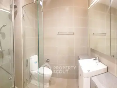 Modern bathroom with glass shower and sleek fixtures in a contemporary apartment.