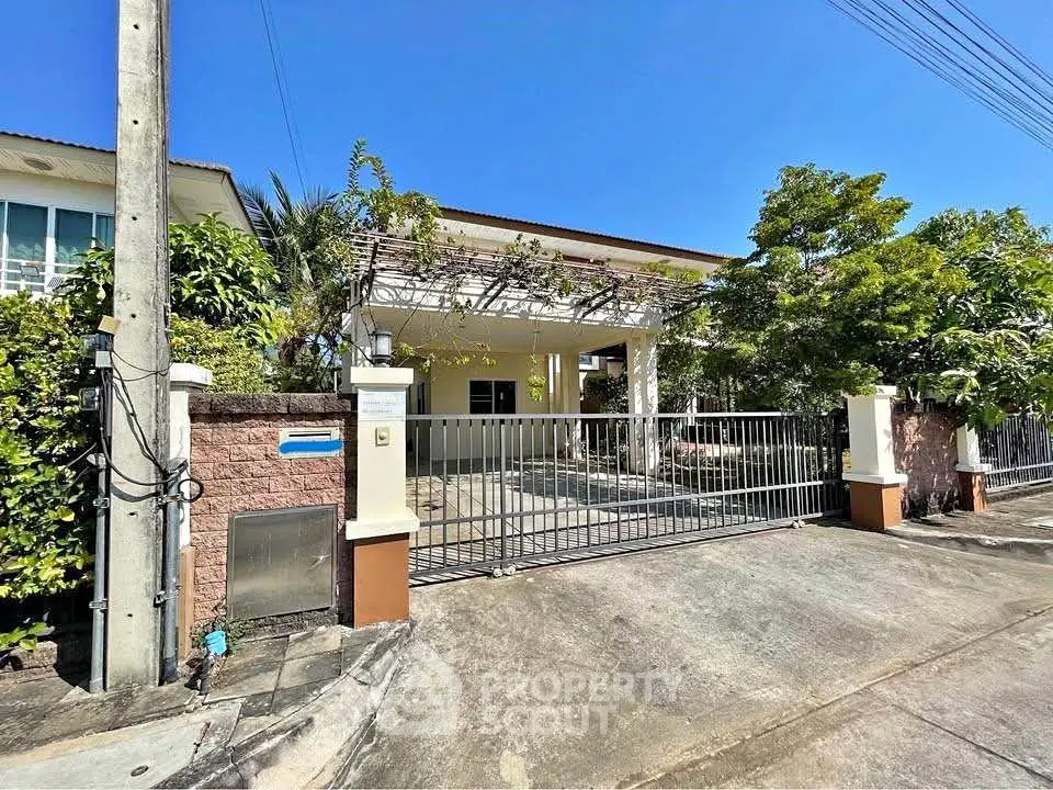 Charming suburban house with gated entrance and lush greenery