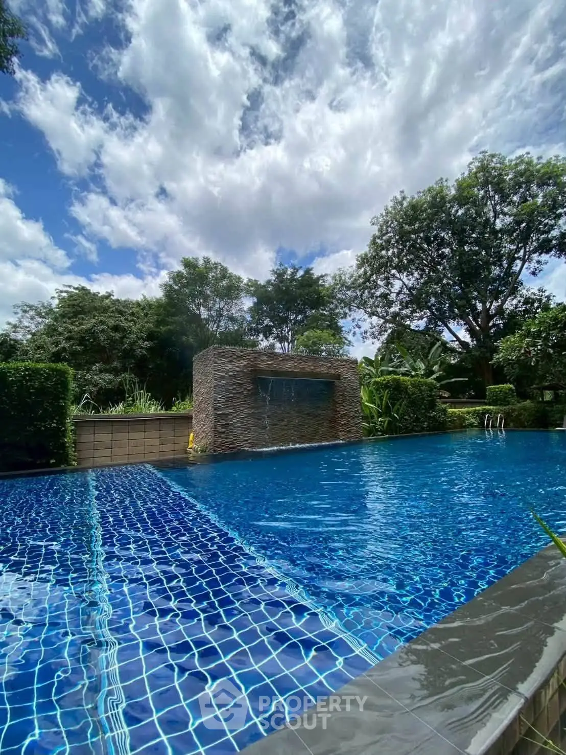 Luxurious outdoor pool with stunning natural surroundings and clear blue sky.