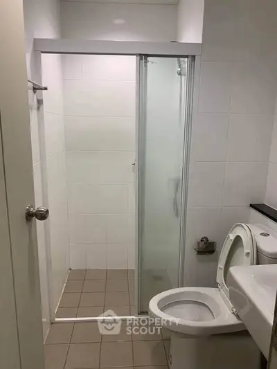 Modern bathroom with glass shower door and tiled flooring