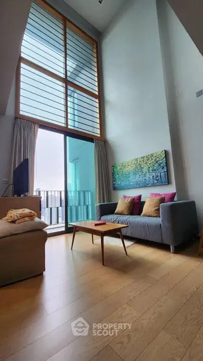 Spacious living room with high ceiling and large windows in modern apartment