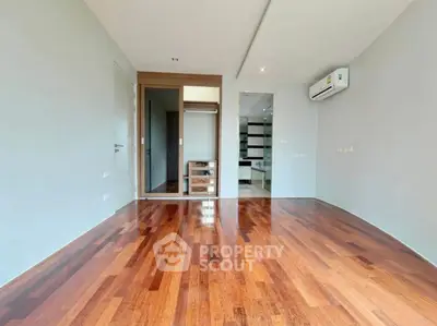 Spacious modern living room with wooden flooring and air conditioning.