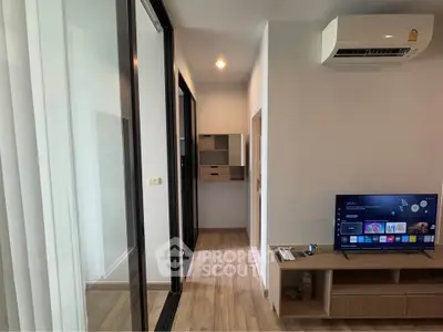 Modern living room with sleek TV setup and air conditioning, perfect for cozy relaxation.