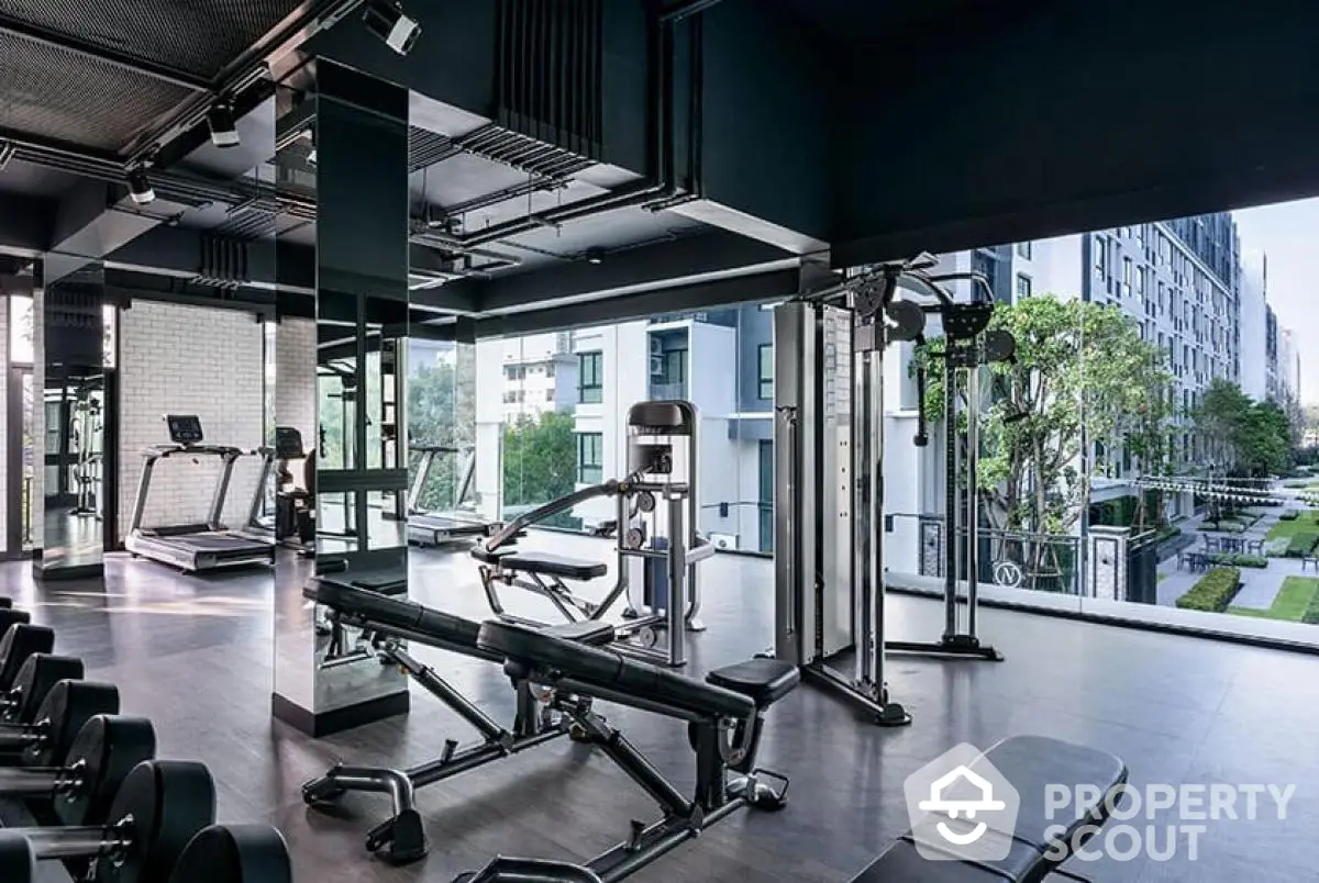 Modern gym with state-of-the-art equipment and panoramic view in luxury apartment complex.