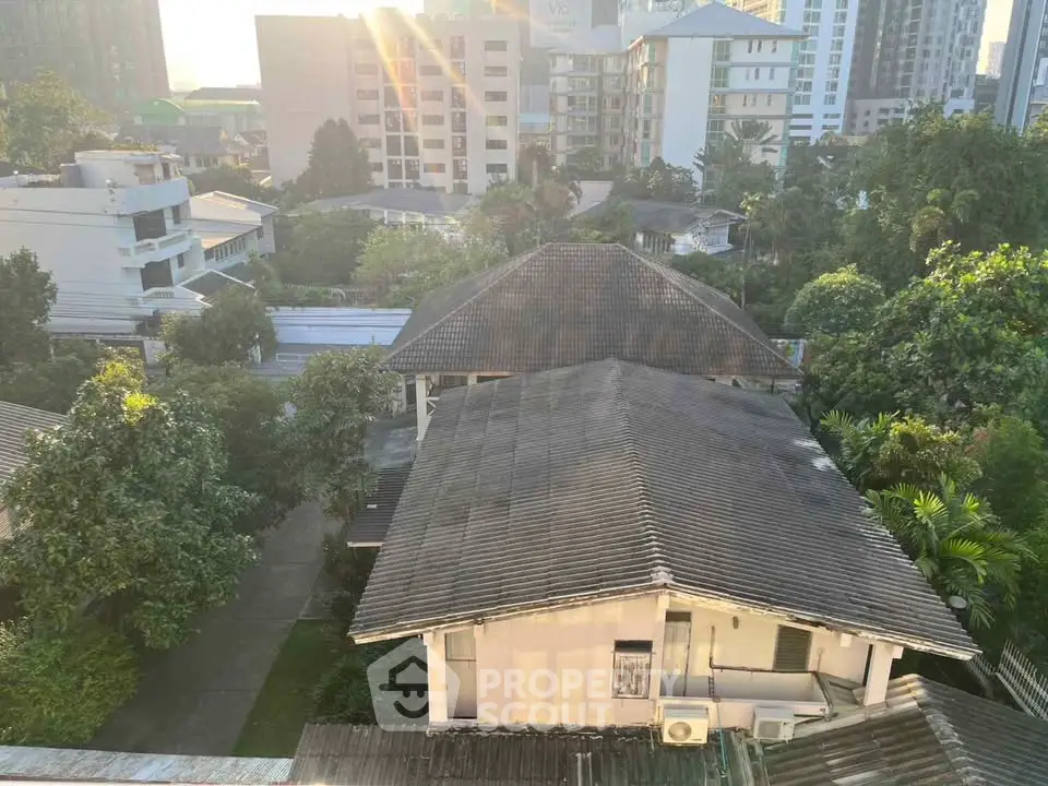 Charming urban view with lush greenery and residential buildings at sunrise.