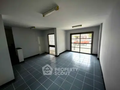 Spacious tiled room with large windows and natural light