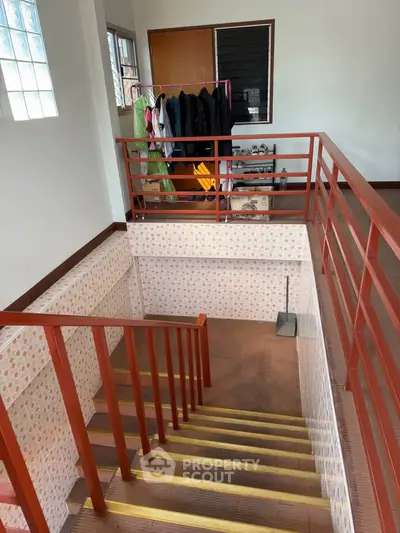 Spacious stairway with modern railing and natural light, perfect for stylish home design.