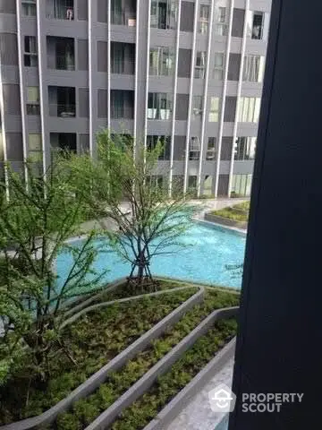 Modern apartment building with lush garden and pool view