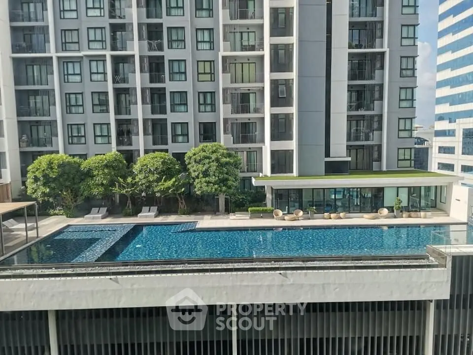Modern apartment building with a luxurious swimming pool and lush greenery, perfect for urban living.