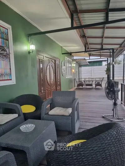 Charming outdoor patio with stylish wicker furniture and decorative wall art.