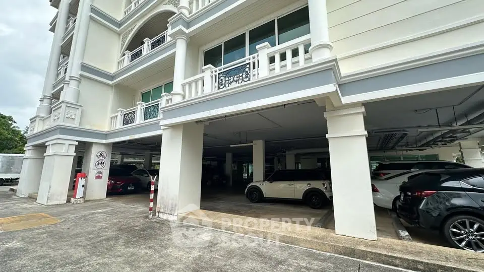 Spacious covered parking area in a modern residential building with multiple vehicles parked.