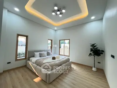 Spacious modern bedroom with elegant lighting and cozy decor