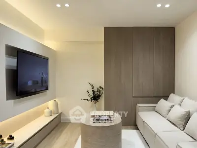 Modern living room with sleek design, neutral tones, and built-in storage.