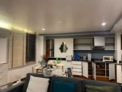 Modern open-layout kitchen with sleek cabinets and cozy living area, perfect for urban living.