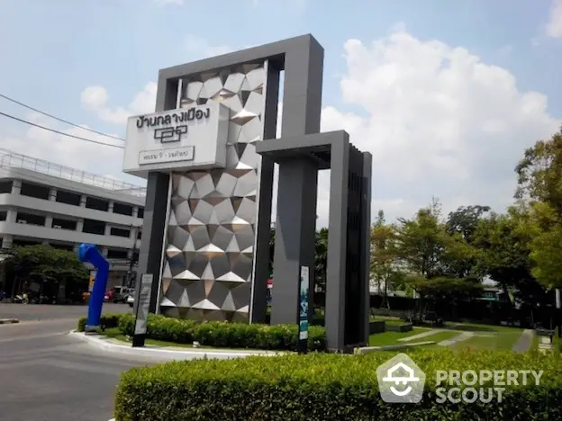 Modern commercial property entrance with stylish geometric design and lush green landscaping, showcasing a welcoming and professional atmosphere.