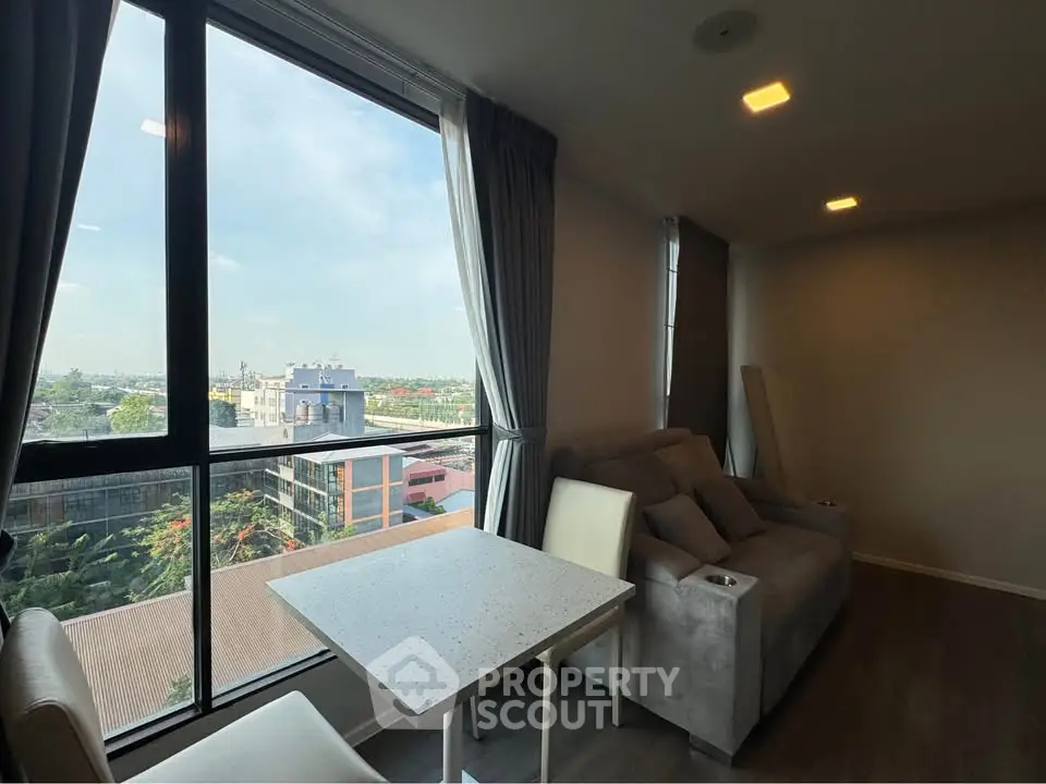 Modern living room with large window offering a stunning city view, cozy seating, and elegant dining area.