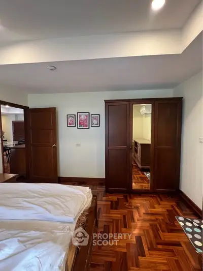 Spacious bedroom with wooden flooring and elegant wardrobe