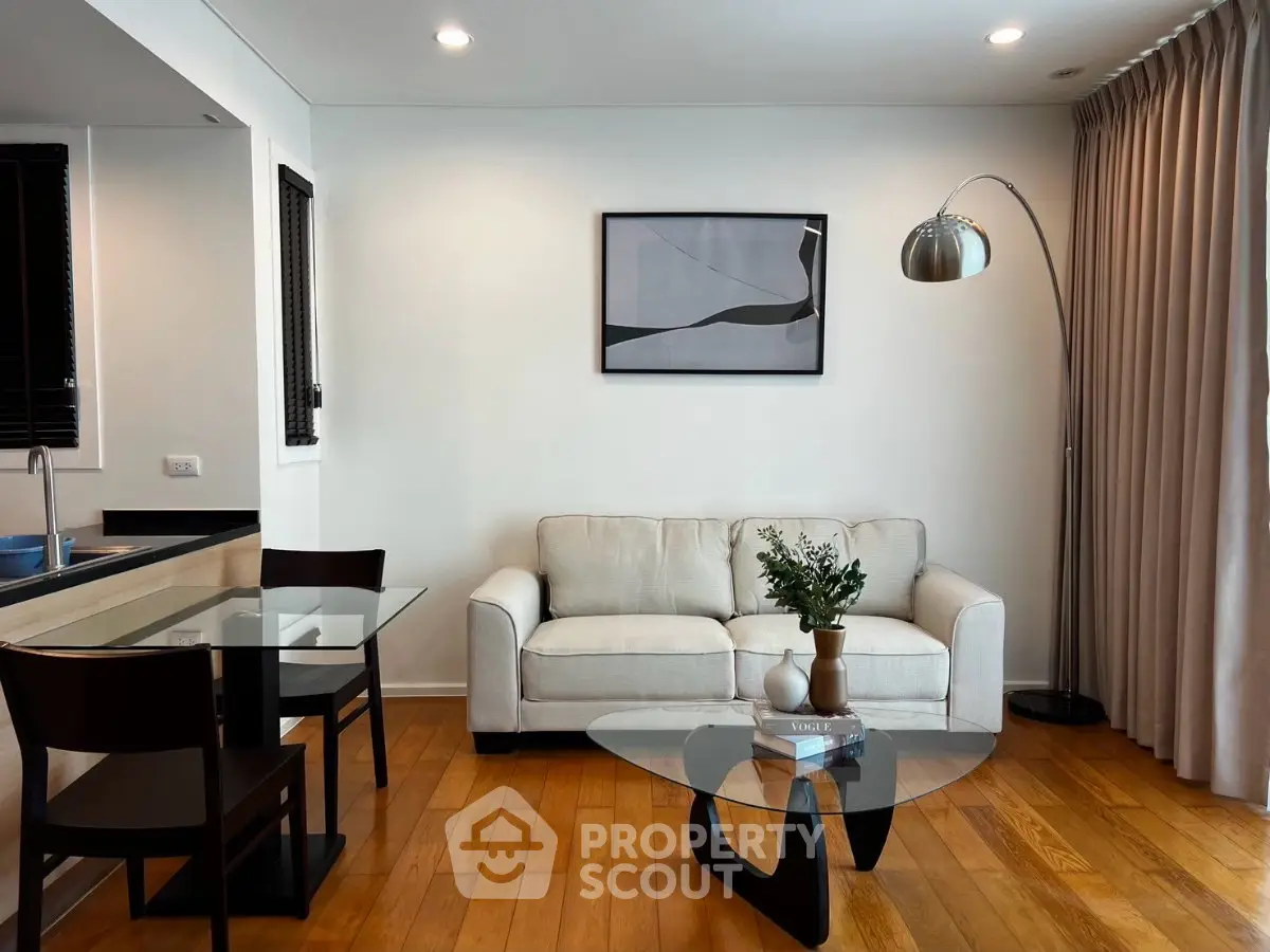 Modern living room with elegant decor, featuring a cozy sofa, stylish glass coffee table, and chic floor lamp.