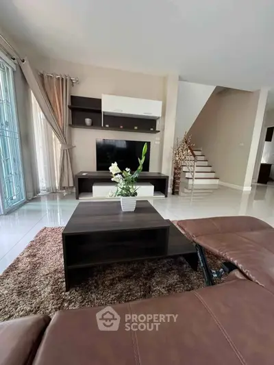 Spacious living room with modern decor and elegant staircase