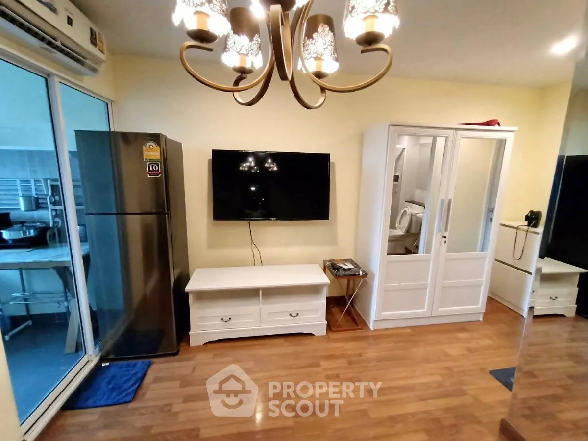 Charming living room with modern decor, featuring a sleek TV setup and elegant lighting, perfect for cozy gatherings.