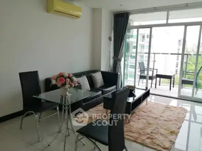 Modern living room with glass table and balcony view in a stylish apartment.