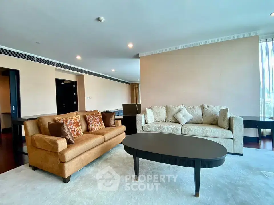 Spacious living room with elegant sofas and modern decor in a luxury apartment.