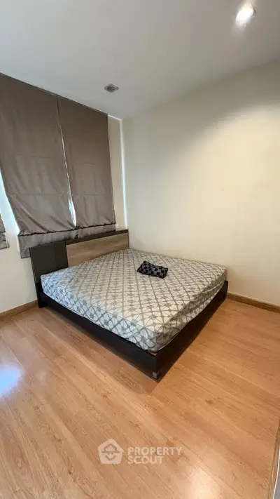 Modern bedroom with wooden flooring and stylish bed in a cozy apartment.