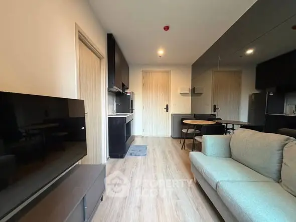 Modern living room with open kitchen layout and stylish furnishings