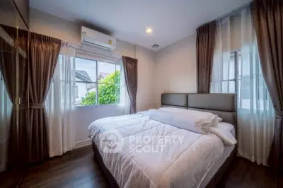 Cozy bedroom with large windows and modern decor, perfect for relaxation.