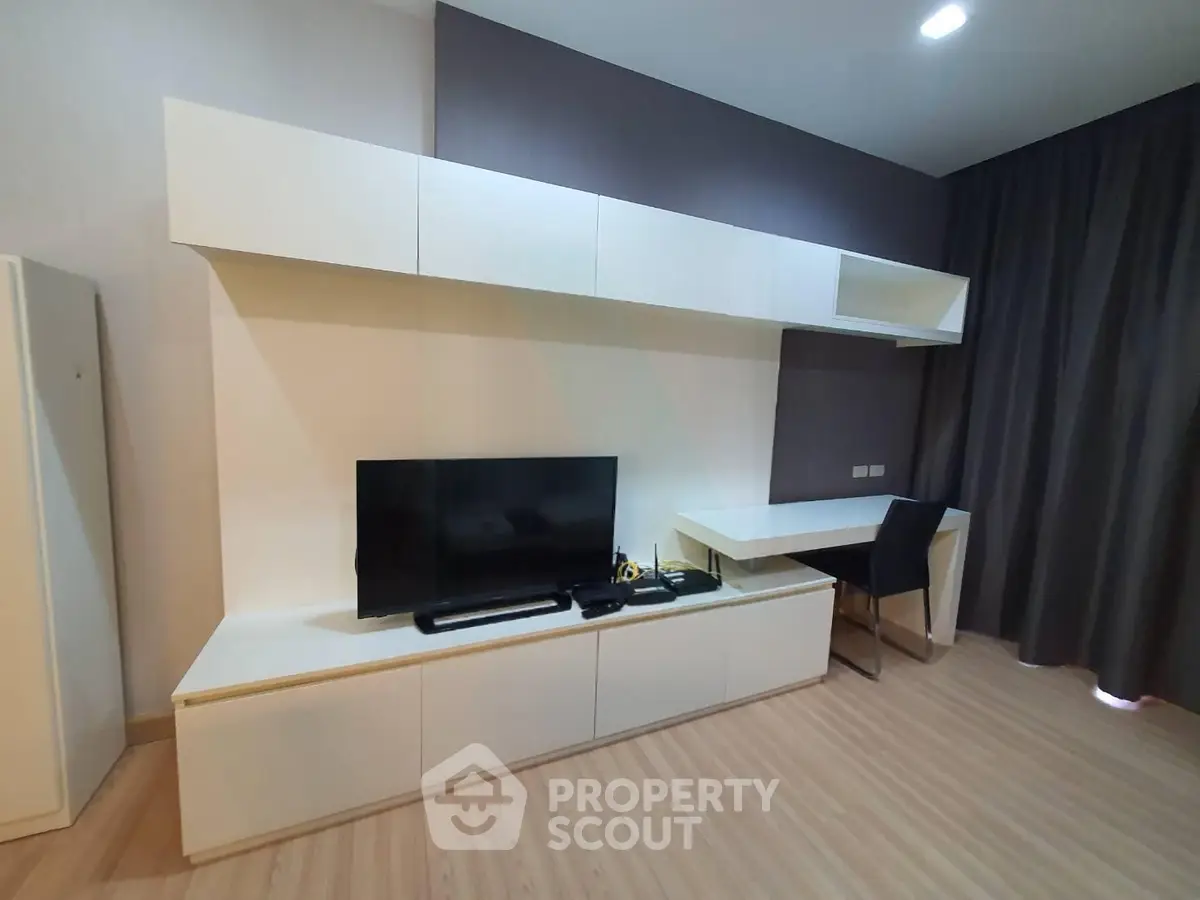 Modern living room with sleek TV unit and study desk, featuring minimalist design and elegant decor.