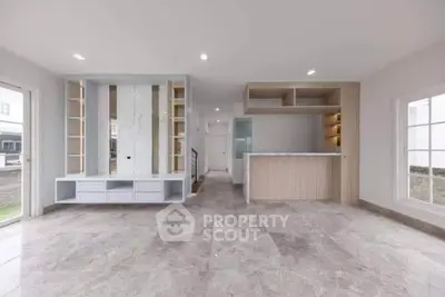 Spacious modern living room with elegant built-in shelves and sleek marble flooring.