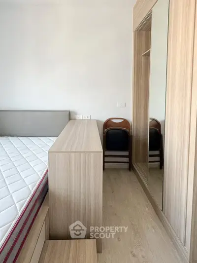 Modern bedroom with minimalist design, featuring a wooden wardrobe and comfortable bed.